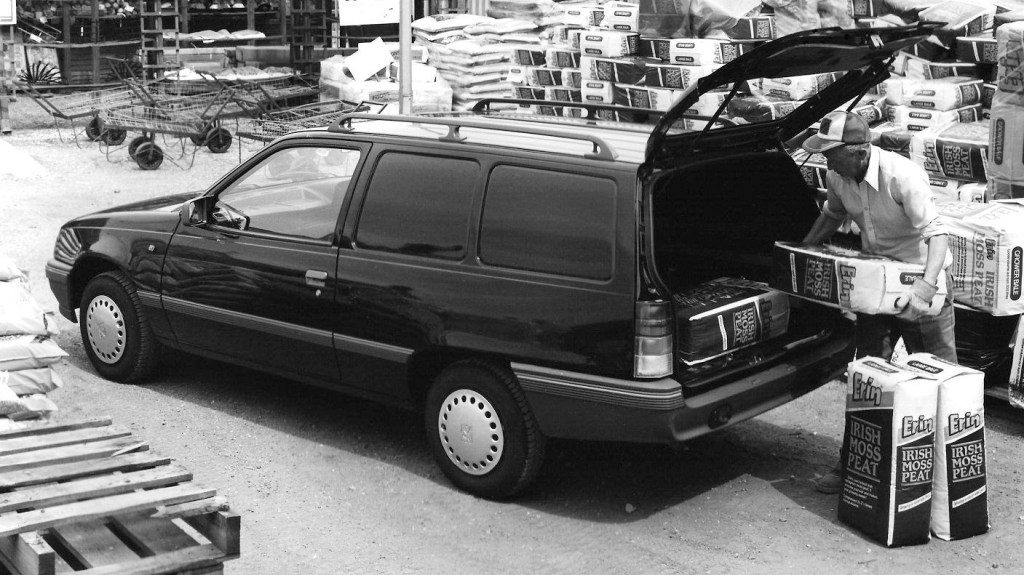 Rear three-quarter of a dark Vauxhall Astravan being loaded with peat